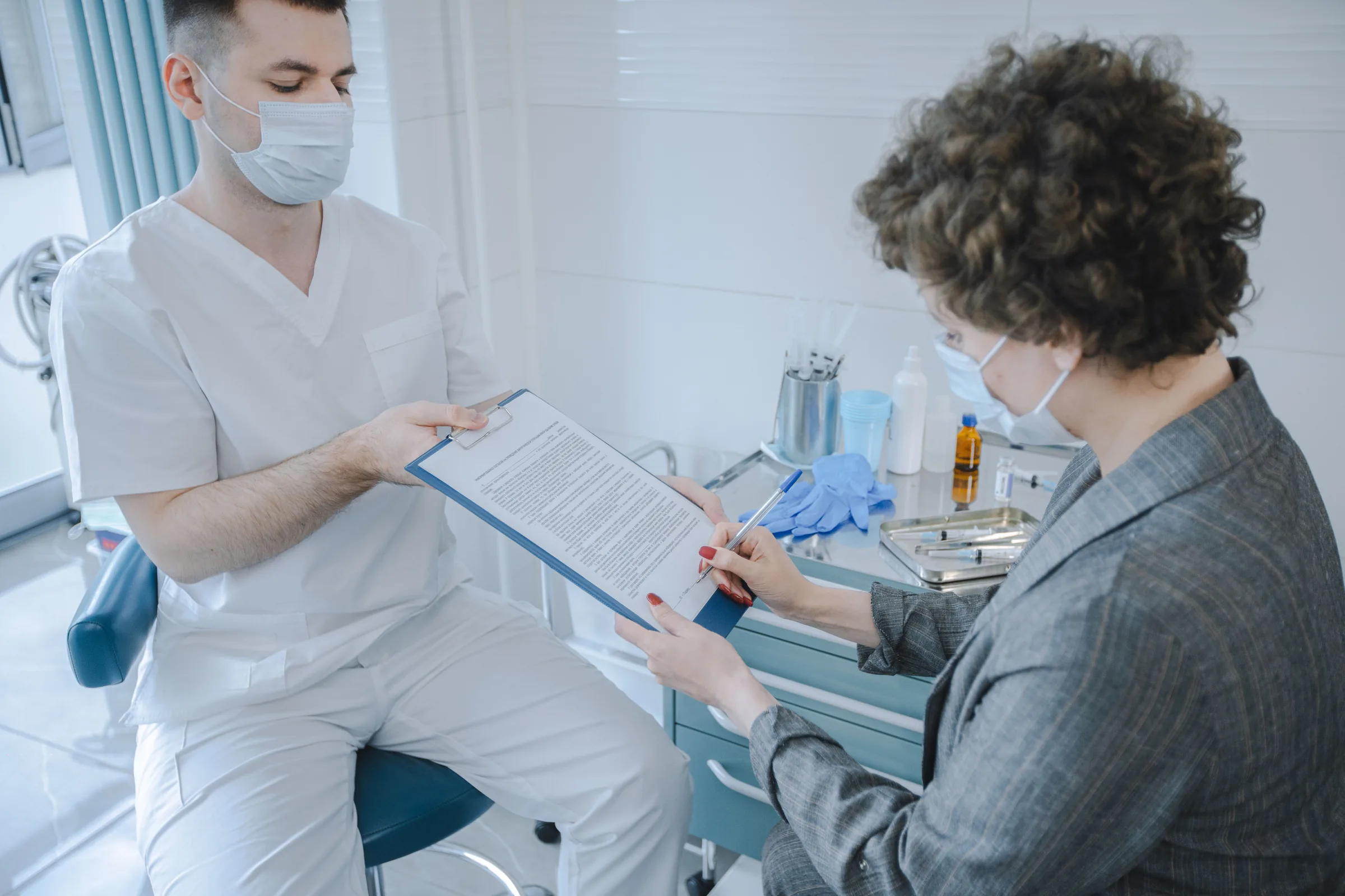 A patient reviewing a treatment plan with a practitioner in a clinical room